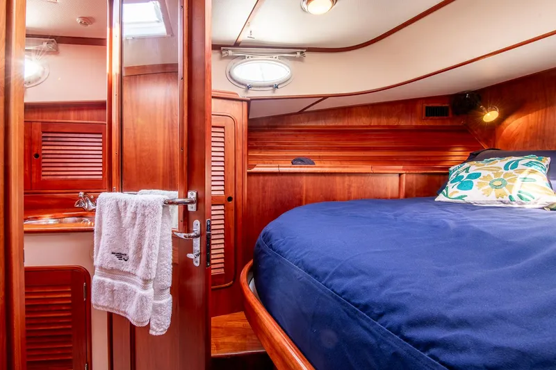 Chic Yacht Photos Pics Hinckley Talaria 44 Express 2003 cabin with wooden interior and cozy bed.