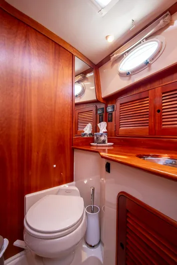 Chic Yacht Photos Pics Luxurious 2003 Hinckley Talaria 44 Express yacht bathroom with wood accents and porthole window.