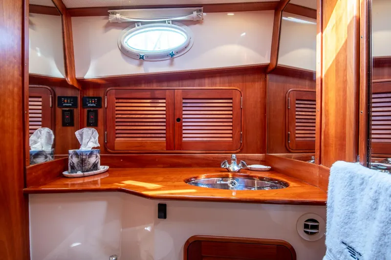 Chic Yacht Photos Pics Luxurious 2003 Hinckley Talaria 44 Express yacht bathroom with wooden cabinetry and modern fixtures.