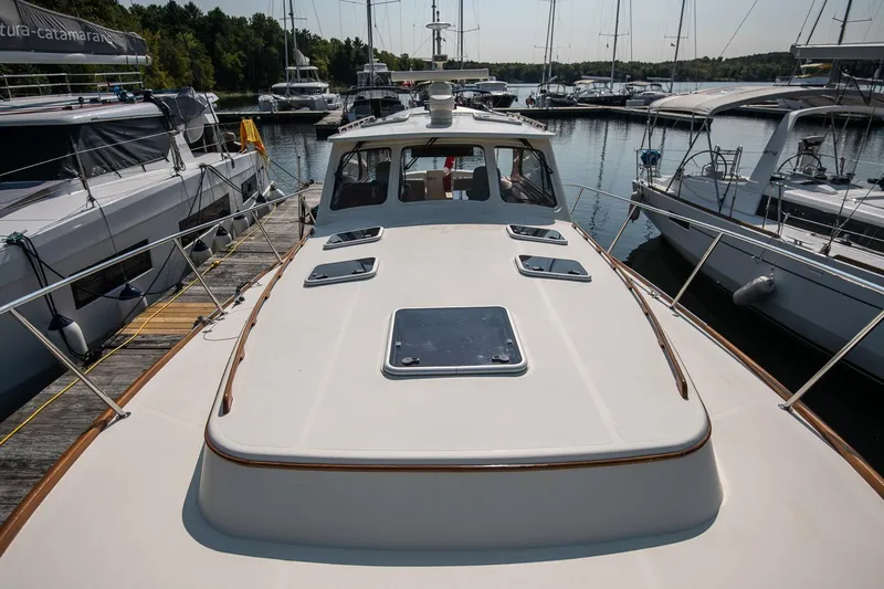 Chic Yacht Photos Pics 2003 Hinckley Talaria 44 Express yacht docked at a marina, surrounded by other boats.