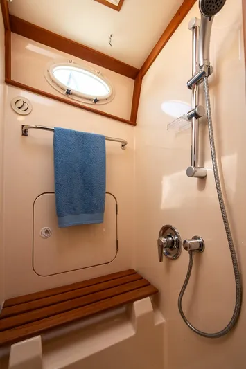 Chic Yacht Photos Pics Shower area in 2003 Hinckley Talaria 44 Express yacht with wooden bench and blue towel.