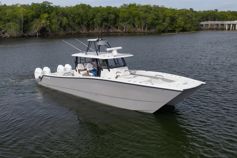  Yacht Photos Pics 2022 Freeman 42LR boat cruising on a calm river with lush green trees.