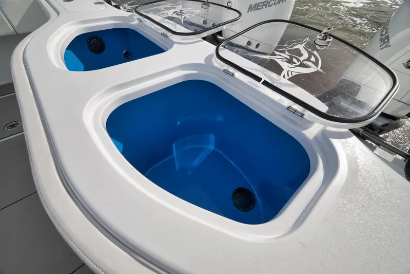  Yacht Photos Pics Livewell compartments on a 2022 Freeman 42LR boat, featuring blue interiors and clear lids.