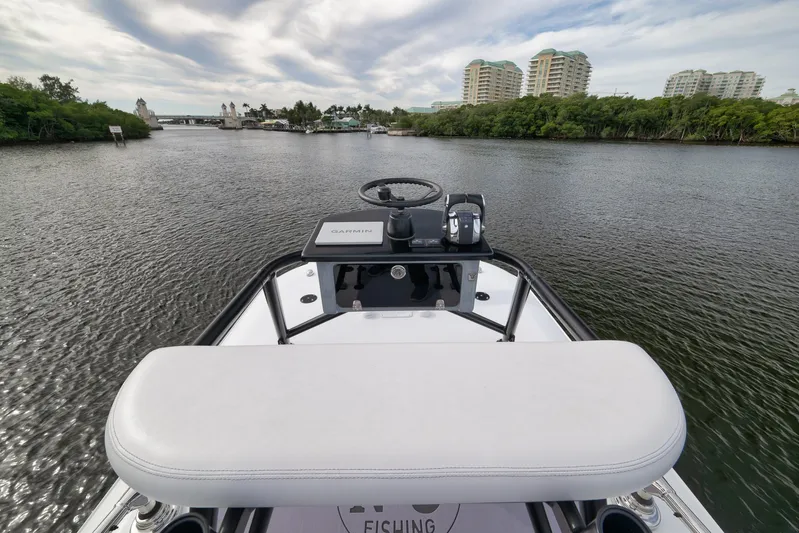  Yacht Photos Pics 2022 Freeman 42LR boat navigating a scenic river with modern buildings in the background.