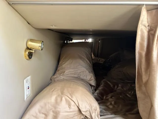  Yacht Photos Pics Interior cabin of 2008 Fountain 38 Sportfish Express Cruiser with bedding and reading light.