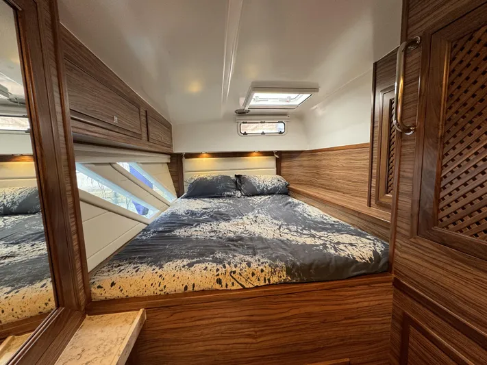 Alora Yacht Photos Pics Luxurious cabin interior of 2023 Knysna 500 SE yacht with wood paneling and cozy bedding.