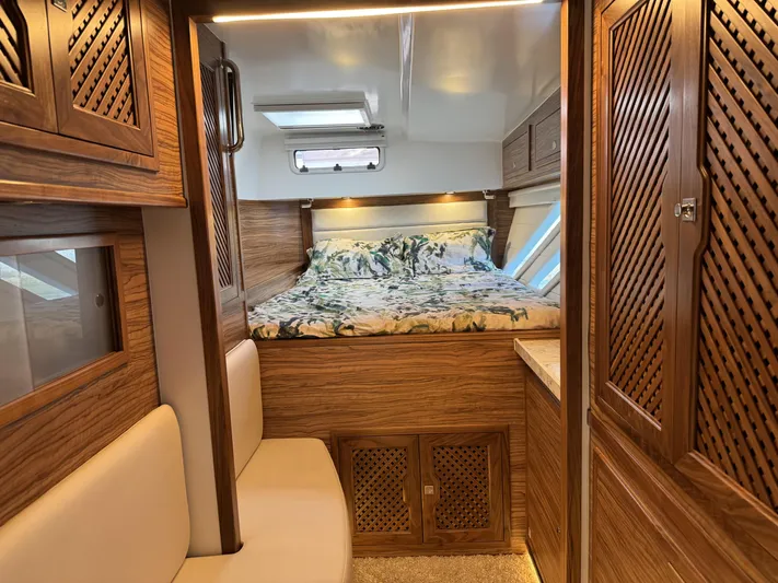 Alora Yacht Photos Pics Luxurious interior of 2023 Knysna 500 SE yacht with cozy bed and wooden cabinetry.