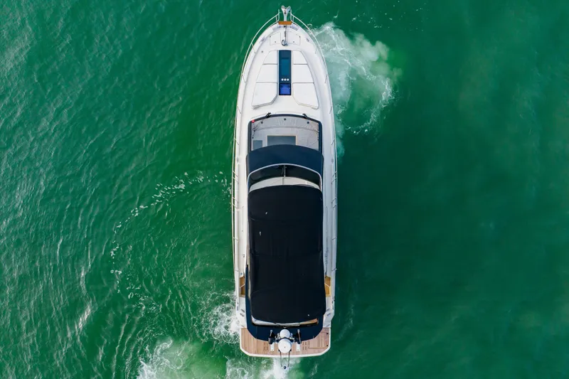 Nauti Obsession Yacht Photos Pics Aerial view of 2015 Monte Carlo MC5 yacht cruising on green water.