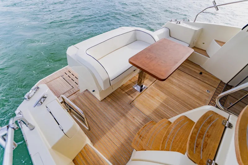 Nauti Obsession Yacht Photos Pics Luxurious 2015 Monte Carlo MC5 yacht deck with seating and wooden table.