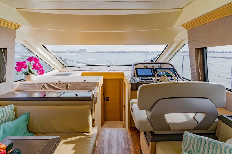 Nauti Obsession Yacht Photos Pics Luxurious 2015 Monte Carlo MC5 yacht interior with helm, seating, and vibrant pink flowers.