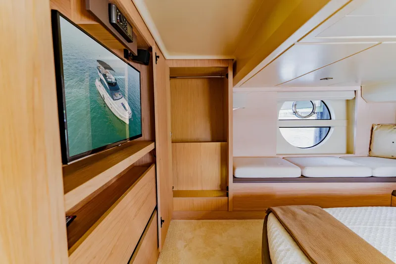 Nauti Obsession Yacht Photos Pics Luxurious Monte Carlo MC5 2015 yacht interior with TV, bed, and porthole window.
