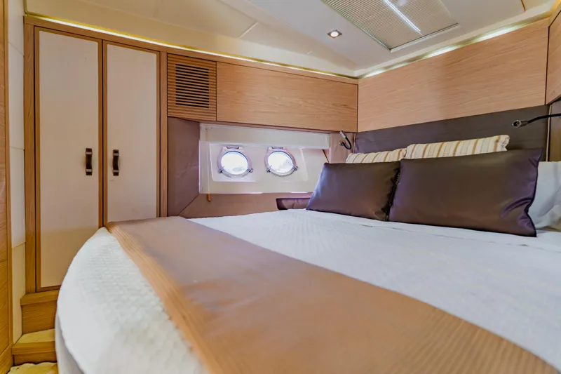 Nauti Obsession Yacht Photos Pics Luxurious Monte Carlo MC5 2015 yacht cabin with elegant bedding and porthole windows.