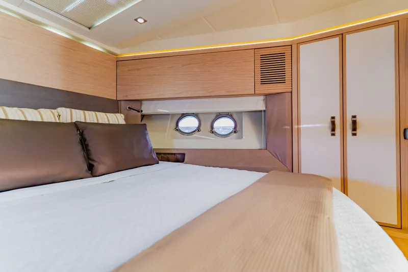 Nauti Obsession Yacht Photos Pics Luxurious interior cabin of 2015 Monte Carlo MC5 yacht with elegant bedding and porthole.