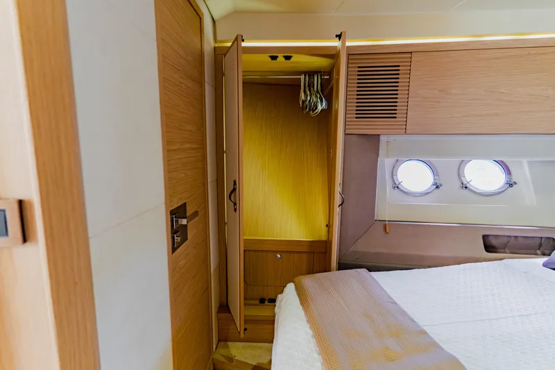 Nauti Obsession Yacht Photos Pics Luxurious Monte Carlo MC5 2015 yacht bedroom with wooden closet and porthole windows.