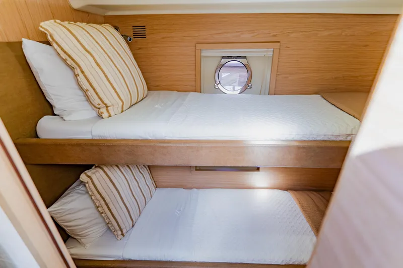 Nauti Obsession Yacht Photos Pics Cozy twin bunk beds in 2015 Monte Carlo MC5 yacht cabin with porthole.