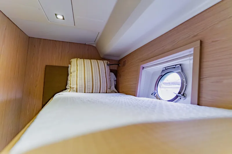 Nauti Obsession Yacht Photos Pics Cozy cabin interior of 2015 Monte Carlo MC5 yacht with porthole and bed.