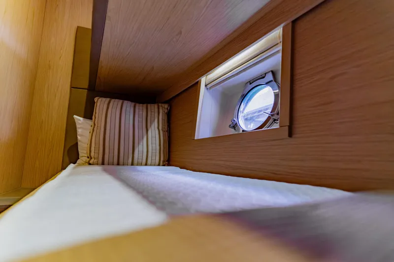 Nauti Obsession Yacht Photos Pics Cozy cabin interior of 2015 Monte Carlo MC5 yacht with porthole and striped pillow.