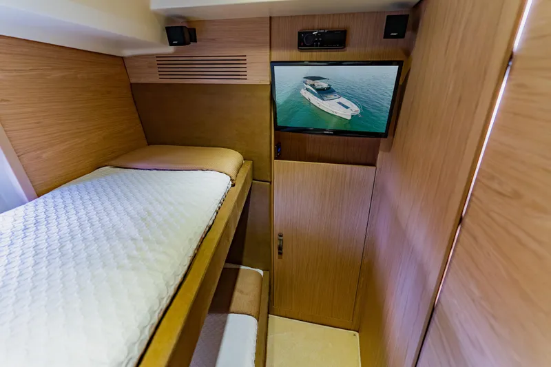Nauti Obsession Yacht Photos Pics Cozy cabin interior of 2015 Monte Carlo MC5 yacht with bunk beds and TV.