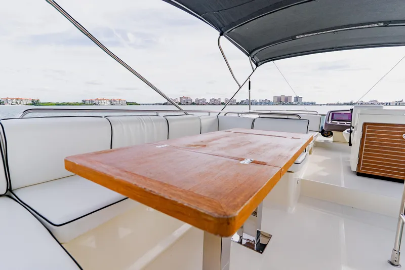 Nauti Obsession Yacht Photos Pics Luxurious 2015 Monte Carlo MC5 yacht interior with wooden table and white seating.