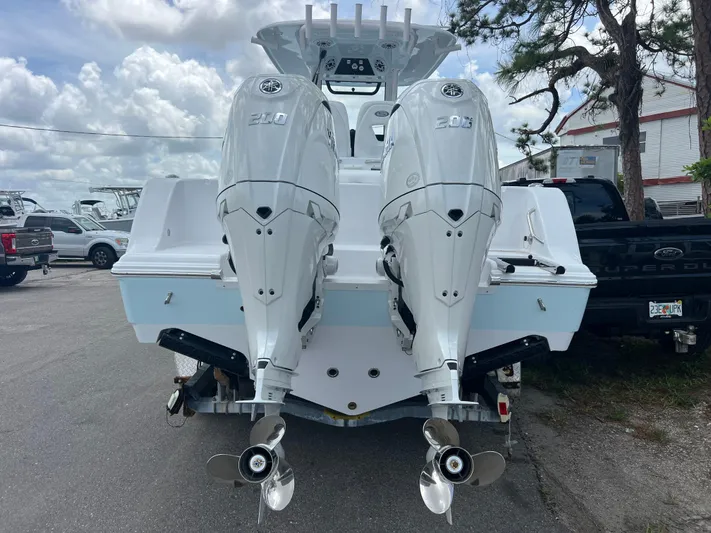  Yacht Photos Pics 2025 Sportsman Open 262 Center Console with twin outboard engines, parked outdoors.