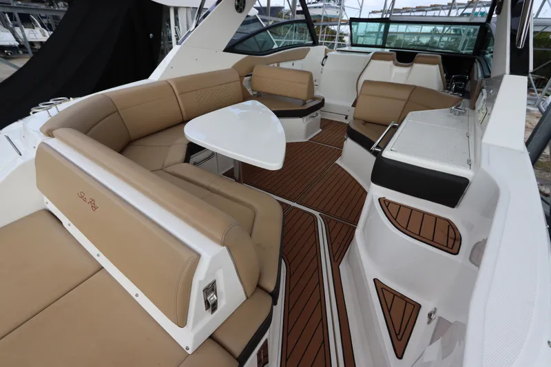  Yacht Photos Pics 2019 Sea Ray Sundancer 320 interior with tan seating, white table, and wood flooring.