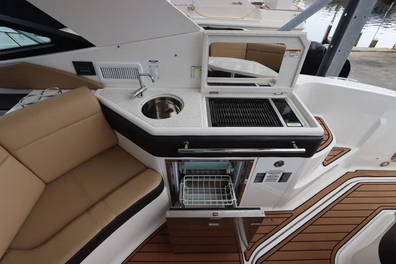  Yacht Photos Pics 2019 Sea Ray Sundancer 320 yacht interior with kitchenette, featuring sink, grill, and seating area.
