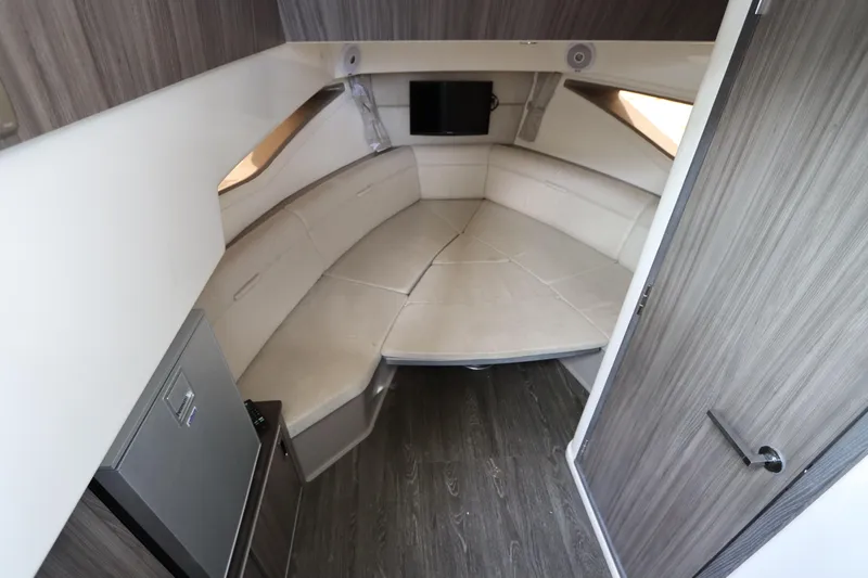  Yacht Photos Pics 2019 Sea Ray Sundancer 320 cabin interior with seating, wood paneling, and a small TV.