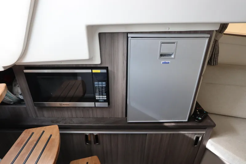  Yacht Photos Pics 2019 Sea Ray Sundancer 320 interior with microwave and fridge in compact kitchen area.