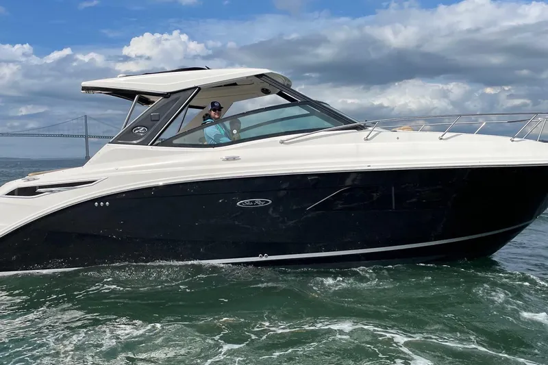  Yacht Photos Pics 2019 Sea Ray Sundancer 320 cruising on the water under a cloudy sky.
