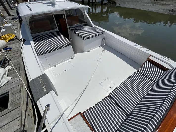 Bushwacker Yacht Photos Pics 1972 Bertram 31 Sedan Hardtop Cruiser with striped seating, docked by the water.