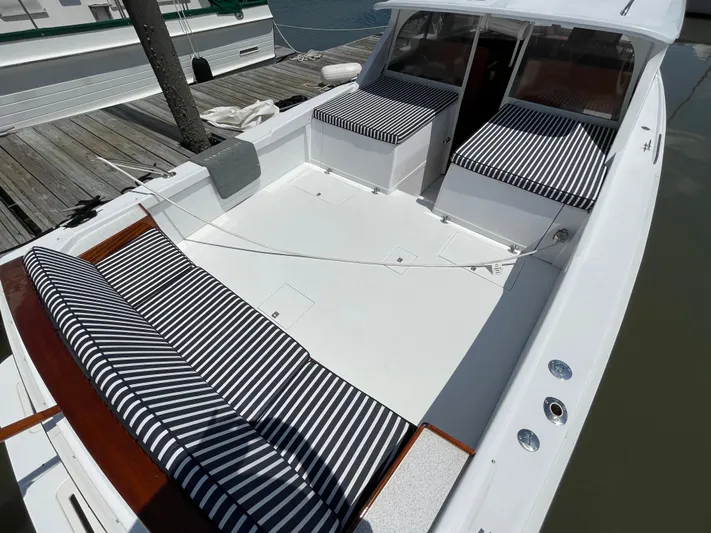 Bushwacker Yacht Photos Pics 1972 Bertram 31 Sedan Hardtop Cruiser with striped seating, docked at a marina.