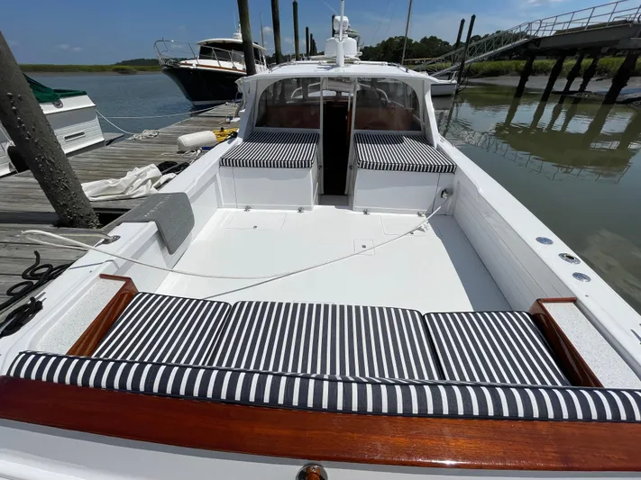 Bushwacker Yacht Photos Pics 1972 Bertram 31 Sedan Hardtop Cruiser with striped seating at a dock.
