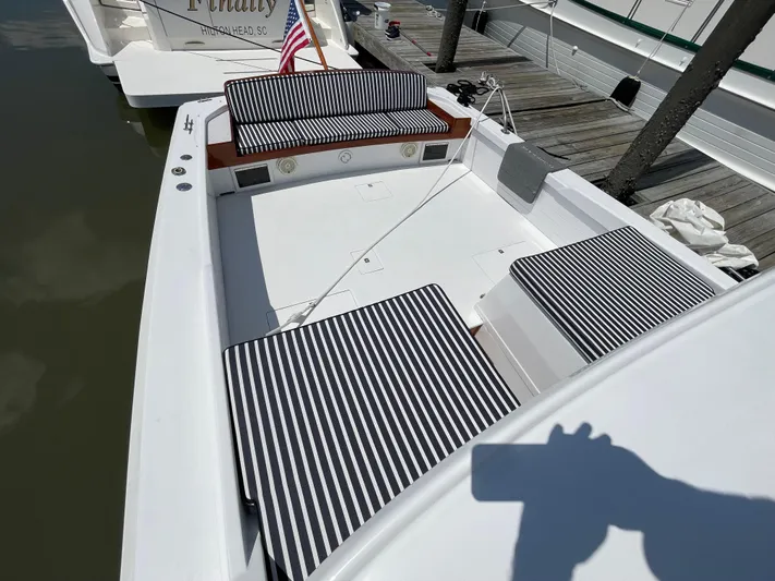 Bushwacker Yacht Photos Pics 1972 Bertram 31 Sedan Hardtop Cruiser with striped seating, docked at a marina.