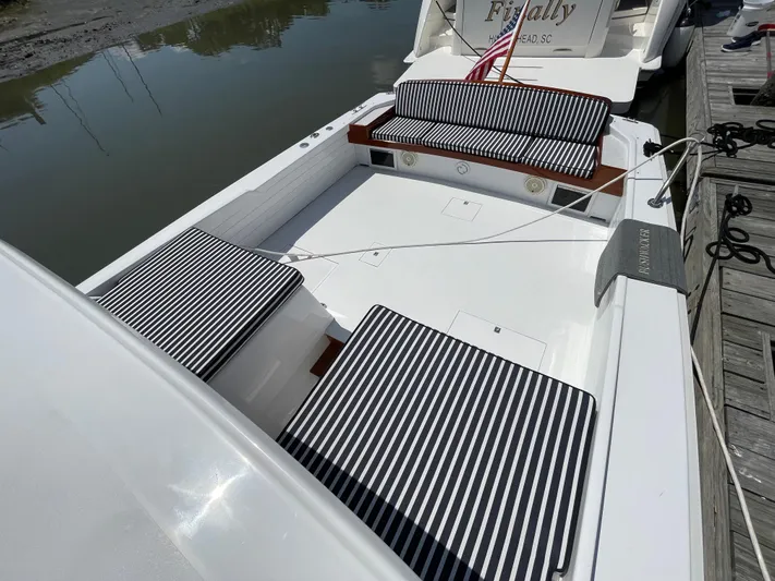 Bushwacker Yacht Photos Pics 1972 Bertram 31 Sedan Hardtop Cruiser with striped seating, docked by the water.