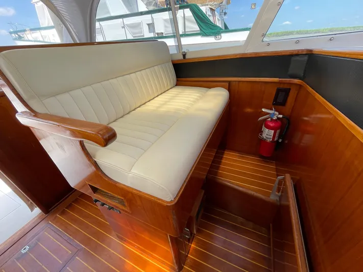 Bushwacker Yacht Photos Pics 1972 Bertram 31 Sedan Hardtop Cruiser interior with white seating and wooden flooring.
