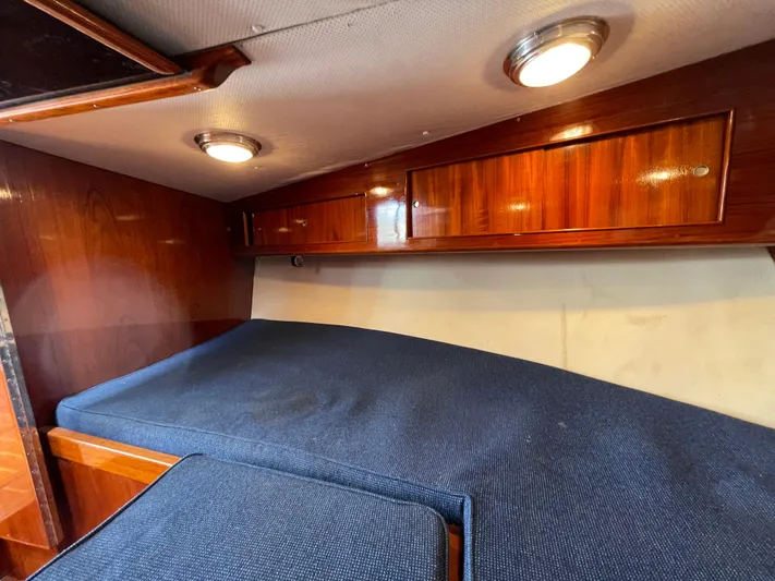 Bushwacker Yacht Photos Pics Interior cabin of 1972 Bertram 31 Sedan Hardtop Cruiser with wood paneling and blue upholstery.