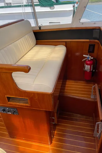 Bushwacker Yacht Photos Pics 1972 Bertram 31 Sedan Hardtop Cruiser interior with wooden seating and fire extinguisher.