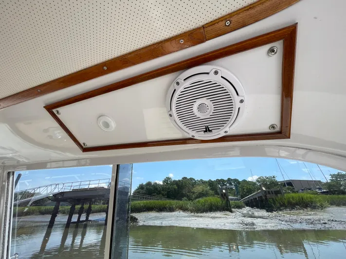 Bushwacker Yacht Photos Pics 1972 Bertram 31 Sedan Hardtop Cruiser interior with speaker and scenic river view.