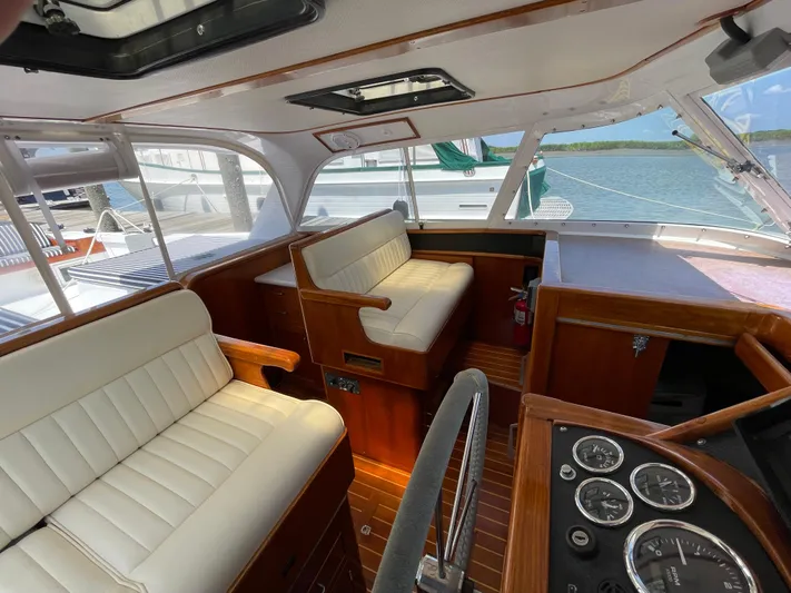 Bushwacker Yacht Photos Pics Interior of a 1972 Bertram 31 Sedan Hardtop Cruiser with white seating and wooden accents.