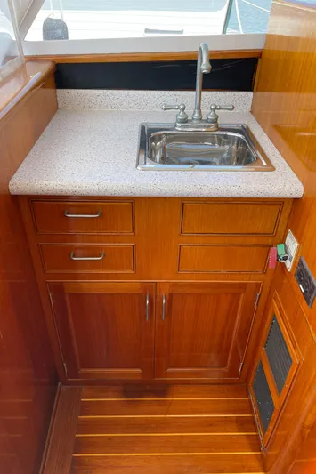 Bushwacker Yacht Photos Pics 1972 Bertram 31 Sedan Hardtop Cruiser interior with wooden cabinetry and compact sink.