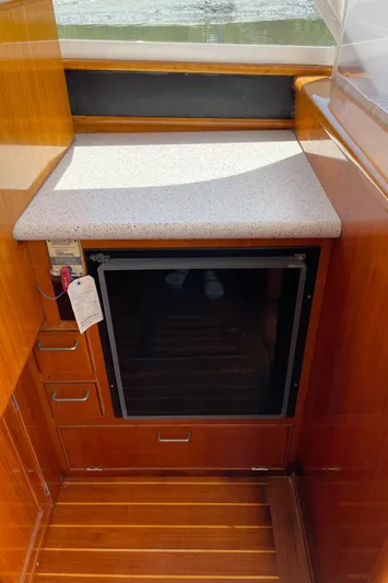 Bushwacker Yacht Photos Pics 1972 Bertram 31 Sedan Hardtop Cruiser interior with wood cabinetry and mini fridge.