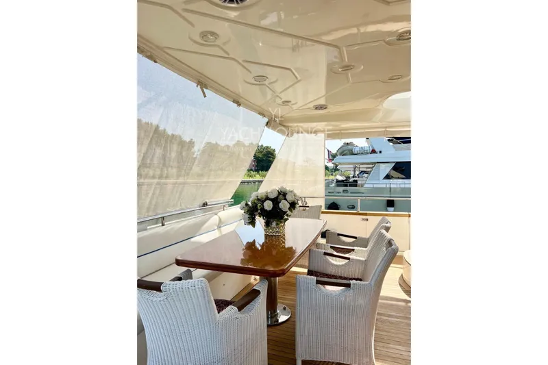  Yacht Photos Pics Luxurious 2004 Azimut 74 Solar yacht deck with elegant dining area and wicker chairs.