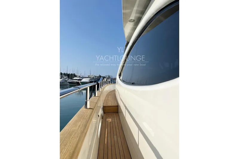  Yacht Photos Pics Side view of 2004 Azimut 74 Solar yacht with wooden deck and marina backdrop.