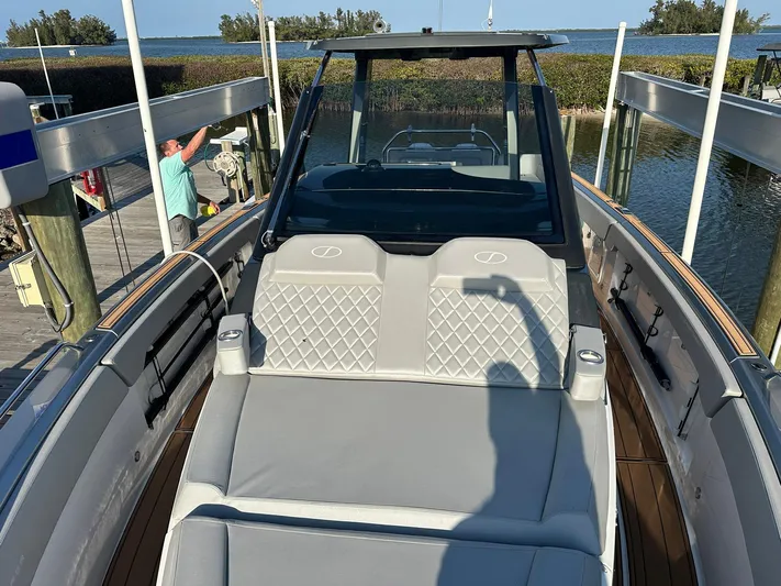 Trouble Maker Yacht Photos Pics 2022 Schaefer V33 boat with luxurious seating, docked by a scenic waterfront.
