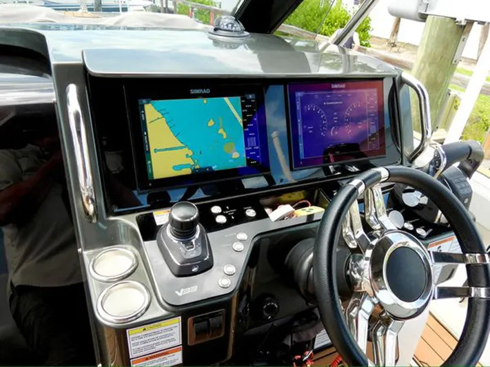 Trouble Maker Yacht Photos Pics Control panel of 2022 Schaefer V33 boat with navigation screens and steering wheel.