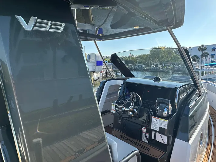 Trouble Maker Yacht Photos Pics 2022 Schaefer V33 boat interior with steering wheel and dashboard, docked at marina.