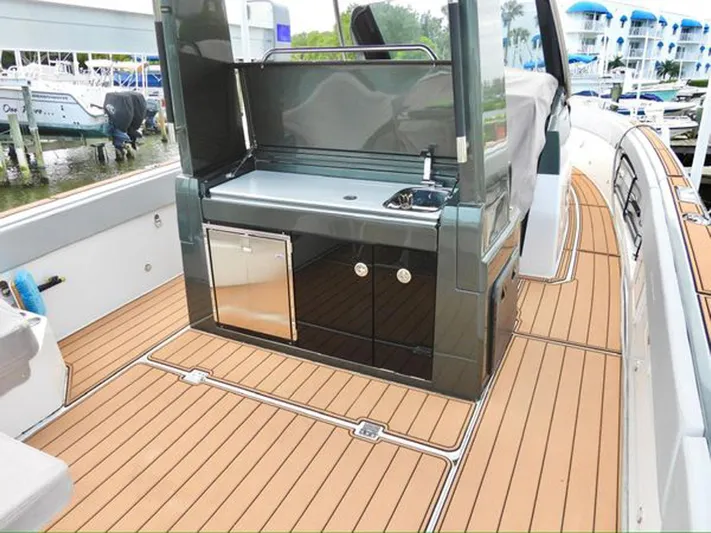 Trouble Maker Yacht Photos Pics 2022 Schaefer V33 boat deck with outdoor kitchen and sleek wood flooring.