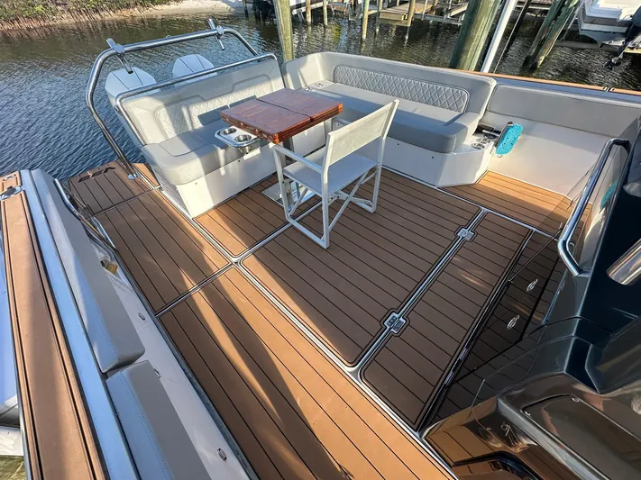 Trouble Maker Yacht Photos Pics Luxurious 2022 Schaefer V33 yacht deck with seating and table, docked by the water.