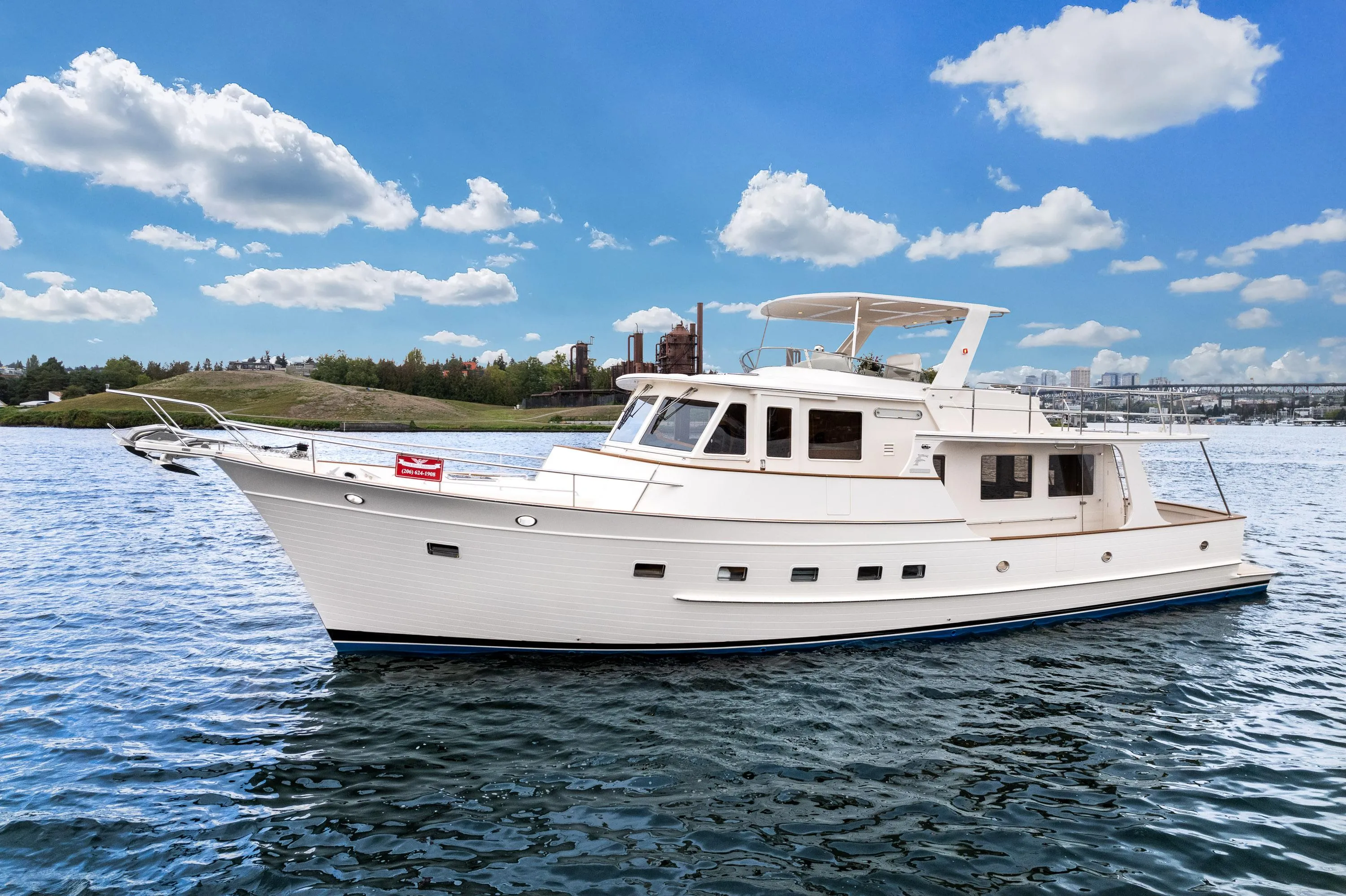 2024 Fleming 58 Pilothouse yacht cruising on a sunny day with blue skies.
