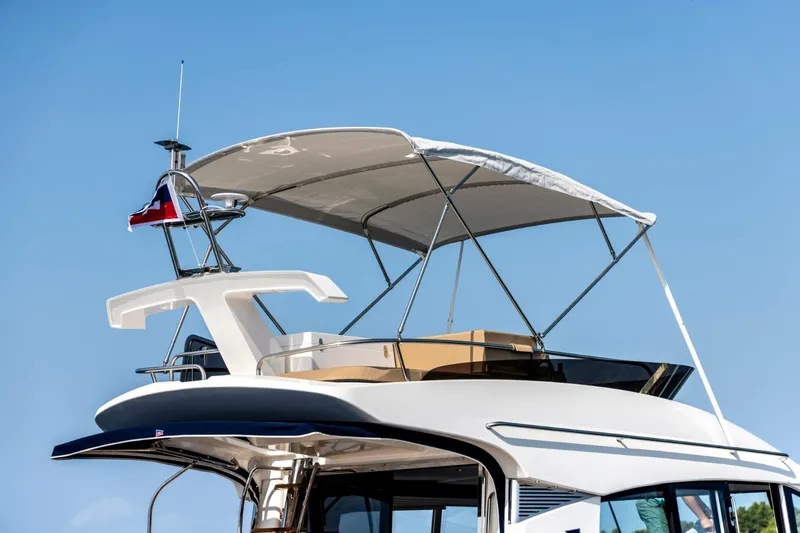  Yacht Photos Pics Nimbus 405 Flybridge 2026 yacht with canopy against clear blue sky.